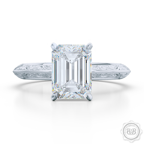Signature Solitaire Engagement Ring featuring an Emerald Step Cut Forever One Moissanite by Charles & Colvard. Handcrafted in White Gold or Precious Platinum. The uniquely structured, soft bevel, shoulders of the ring are ornate with hand carved baroque swirls. Free Shipping for All USA Orders. 30-Day Returns | BASHERT JEWELRY | Boca Raton, Florida