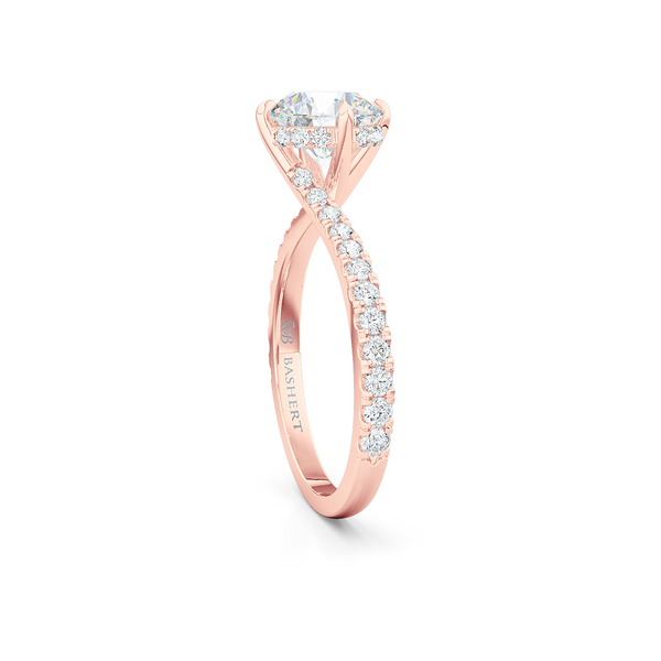 East-West, four prong, Round Solitaire. Recessed diamond halo. Diamond adorned shoulders. Hand-fabricated in Romantic Rose Gold. Available in Diamond or Lab-Grown Diamond. | Made in Boca Raton, Florida. 15 Day Returns. Free Shipping USA. | Bashert Jewelry 