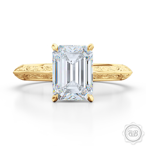 Signature Solitaire Engagement Ring featuring an Emerald Step Cut Forever One Moissanite by Charles & Colvard. Handcrafted in Classic Yellow Gold. The uniquely structured, soft bevel, shoulders of the ring are ornate with hand carved baroque swirls. Free Shipping for All USA Orders. 30-Day Returns | BASHERT JEWELRY | Boca Raton, Florida