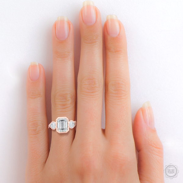 Three stone Moissanite engagement ring. Emerald Cut Forever One Moissanite by Charles & Colvard. Pear shape side stone Moissanites. Handcrafted in Romantic Rose Gold. Free Shipping on All USA Orders. 30-Day Returns | BASHERT JEWELRY | Boca Raton, Florida